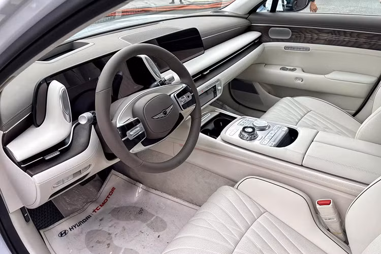 Bước vào khoang nội thất, Genesis G90 mang lại cảm giác sang trọng với nhiều vật liệu cao cấp như da, gỗ và kim loại. Không gian lái được bố trí ba màn hình hiện đại, bao gồm hai màn hình đôi kích thước 12,3 inch và một màn hình điều khiển cảm ứng phía dưới. Cụm cần số dạng núm xoay cùng các phím chức năng được bố trí gọn gàng, dễ sử dụng.