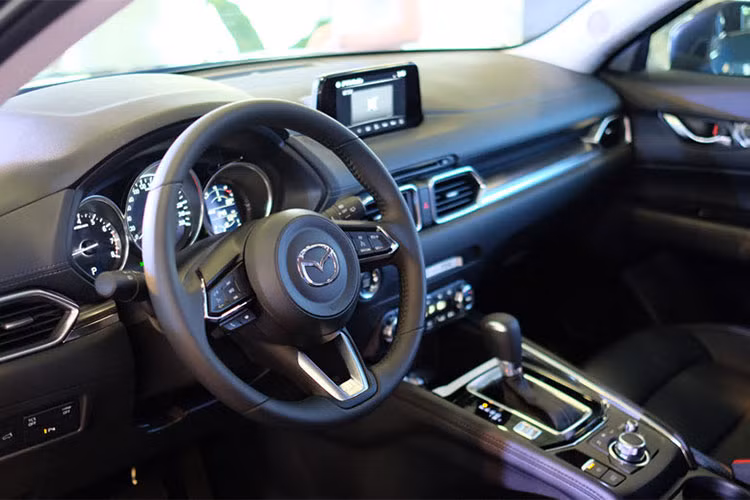 Bên trong nội thất xe cũng thay đổi toàn diện, nhấn mạnh vào triết lý tập trung vào con người. Màn hình giải trí trung tâm của CX-5 cũng nhô lên. Cửa gió điều hòa góc cạnh hơn, dùng vật liệu crôm sang trọng để làm viền. Nút bấm Start/Stop bố trí ra ngoài, không còn nằm sâu sau vô-lăng như đời trước. Vô-lăng thay đổi thiết kế.