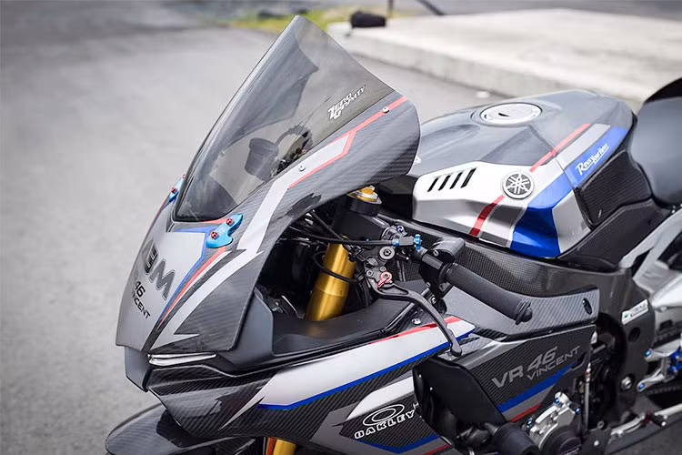 Phần đầu xe của chiếc xe Yamaha R1M độ này hầm hố hơn sau khi được chủ nhân trang bị kính gió Zero Gravity cỡ lớn. Với bộ kính gió này, người lái có thể núp gió sâu hơn, chiếc xe hoàn toàn có thể vượt qua lực cản gió một cách tốt nhất nhằm đem lại gia tốc cao hơn so với xe xuất xưởng.