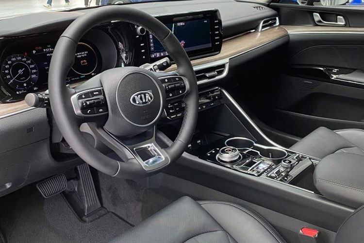 Bên trong Kia Optima 2020 được trang bị màn hình cảm ứng 10,25 inch của hệ thống thông tin giải trí nằm độc lập trên mặt táp-lô, nối liền với bảng đồng hồ kỹ thuật số có màn hình LCD 12,3 inch. Bên cạnh đó là vô lăng hình chữ D thể thao, cửa gió điều hòa, nút bấm chuyển số thay cho cần số truyền thống, đèn viền nội thất, thay đổi màu sắc theo chế độ lái, hệ thống âm thanh Krell, khay sạc điện thoại thông minh không dây...