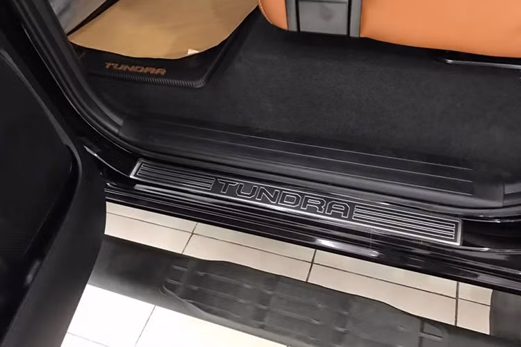 Tuy nhiên ở bên trong nội thất, chiếc xe đã được "nâng tầm đẳng cấp" về sự sang trọng, tương đương với các dòng xe Lexus. Toàn bộ nội thất của chiếc xe đã được bọc trong da màu nâu cafe cao cấp, kết hợp với nhung thượng hạng và những chi tiết ốp gỗ óc chó với vân đẹp mắt. Ngay trên bậc cửa lên xuống của xe cũng có dòng chữ Tundra nổi bật.