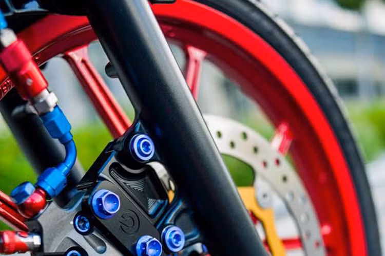 Bánh trước của chiếc xe còn có các món đồ chơi như mâm Daytona hàng hiệu với tông màu đỏ nổi bật thay cho nguyên bản, đĩa Brembo kết hợp heo Brembo được tô điểm bằng đội hình ốc Proti, dây dầu Earl's tự do sáng tạo với góc quay 90 độ cùng các khúc nối ngắt dầu Staubli CNC.