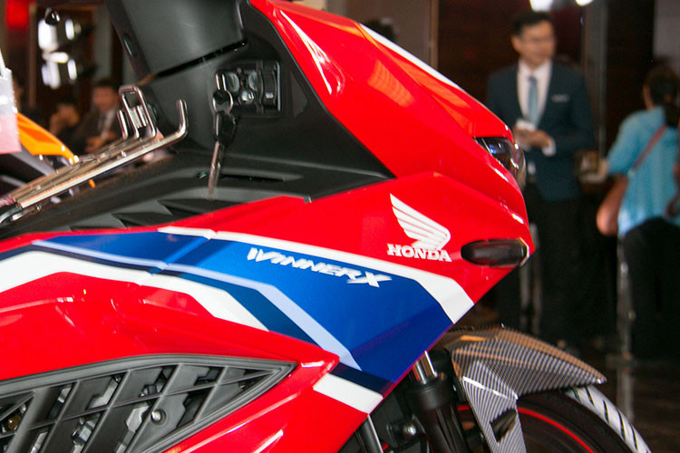Honda Winner X nâng cấp mới được phá cách khi đặt hai đèn xi nhan trước ra hai bên mặt nạ, đây cũng là điểm yếu của xe khi dễ gãy khi va chạm nhẹ. Mặt đồng hồ LCD dạng âm bản nhỏ gọn vay mượn từ đàn anh CBR150R. Hai bên thân xe gây ấn tượng với những đường cắt gọt tạo nên vẻ góc cạnh cùng các khe hút gió dọc thân xe. Phần yên xe được chia 2 tầng rõ rệt, yên trước thấp và yên sau cao hơn.