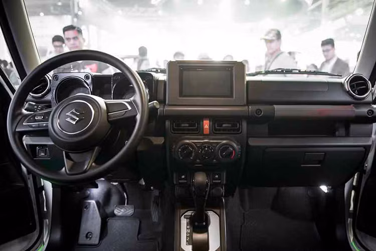 Bên trong Suzuki Jimny 2019 là không gian nội thất cũng được thiết kế theo phong cách đơn giản và dễ hiểu. Hãng Suzuki đã chọn màu đen cho nội thất để giảm thiểu những sự xao nhãng không cần thiết. Đặc biệt, xe sẽ được trang bị màn hình cảm ứng điện dung 9 inch cho hệ thống thông tin giải trí, đi kèm định vị toàn cầu GPS. 