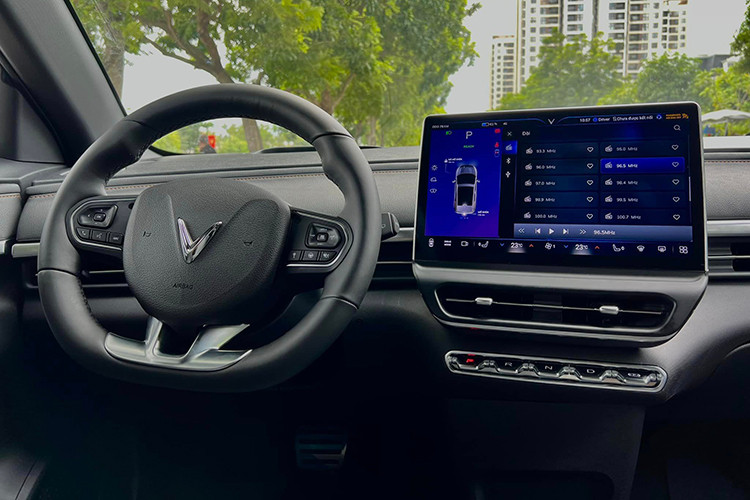 Bên trong khoang nội thất, màn hình của VinFast VF6 thương mại đã có phần viền mà hình mỏng hơn trước đây tạo cảm giác sang trọng, tinh thế hơn cho chiếc SUV này. Màn hình này kích thước 12,9 inch và người lái có thêm màn hình HUD trên kính lái.