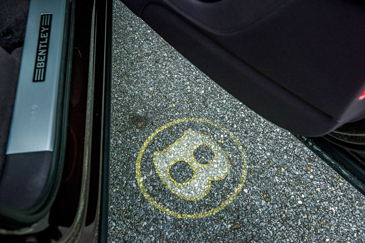 Chiếc SUV siêu sang Bentley Bentayga V8 của doanh nhân quận 12 còn thuộc phiên bản kỷ niệm 100 năm ngày ra đời của hãng xe Anh quốc này. Điều này thể hiện rõ nhất qua việc logo Bentley có thêm đường viền vàng và ký hiệu 1919-2019 như dấu hiệu nhận biết đây là chiếc Bentley Bentayga sản xuất trong năm 2019.