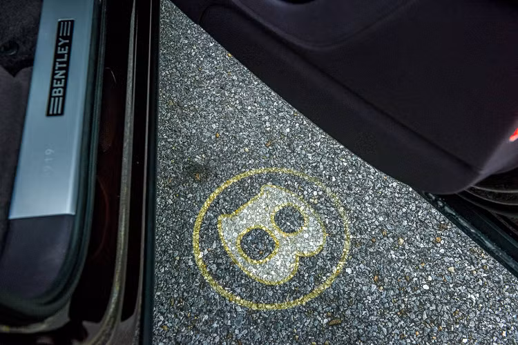 Chiếc SUV siêu sang Bentley Bentayga V8 của doanh nhân quận 12 còn thuộc phiên bản kỷ niệm 100 năm ngày ra đời của hãng xe Anh quốc này. Điều này thể hiện rõ nhất qua việc logo Bentley có thêm đường viền vàng và ký hiệu 1919-2019 như dấu hiệu nhận biết đây là chiếc Bentley Bentayga sản xuất trong năm 2019.