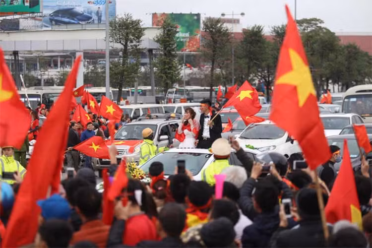 Tuy nhiên không cảm thấy phiền lòng, cả cô dâu và chú rẻ liền diện băng rôn, choàng Quốc kỳ và vẫy cờ hoà cùng bầu không khí xung quanh.