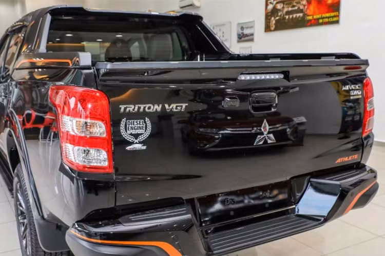 Phía sau là cụm đèn hậu thiết kế cách điệu, dạng chia tầng, cản sau mở rộng có bặc lên thùng. Phía nắm thùng sau ngoài lôgo thương hiệu của hãng xe ôtô Mitsubishi, tên xe còn kèm biểu tượng phiên bản đặc biệt.