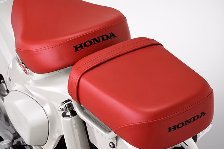 Thân xe khoác lên màu trắng "Ordinary White" tạo cảm giác thanh lịch, sang trọng, trong khi yên xe bọc màu đỏ "Artisan Red" mang đậm phong cách cổ điển. Ngoài ra, một số chi tiết mạ crôm như ốp ống xả và logo C125 màu đỏ nổi bật trên phần yếm xe càng làm tăng thêm vẻ đẹp tinh tế và giá trị thẩm mỹ cho mẫu xe này. 