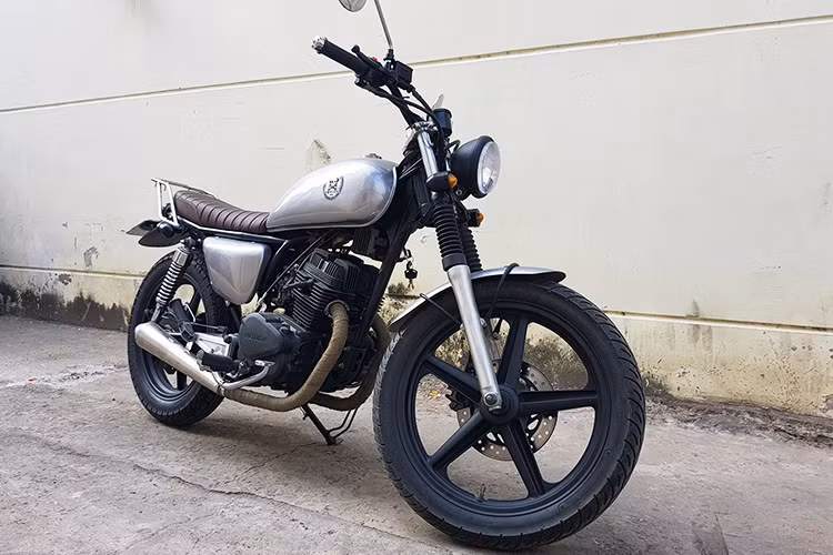 Chiếc xe Honda CB125T nguyên bản được tháo bỏ hoàn toàn lớp vỏ cũ và tiến hành các công đoạn độ. Trên bản độ này, chiếc xe đã được Garage Tự Thanh Đa làm mới với đèn chiếu sáng tròn cổ điển, xi nhan "hột vịt" cá tính. Cụm tay lái thiết kế cao và dễ dàng điều khiển hơn.