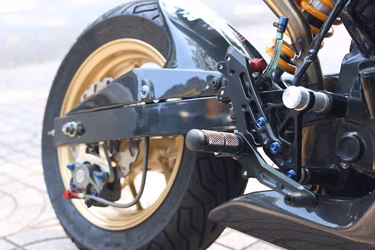 Ở dàn chân sau, ngoài việc nâng cao phân đuôi lên - chiếc xế độ cỡ nhỏ được trang bị phuộc sau Ohlins, gắp sau được thửa riêng cho xe đầy ấn tượng. Lốp sau Michelin CityGrip lớn hơn so với nguyên bản, cùng hầu hết các chi tiết nhựa trên xe đều la carbon.