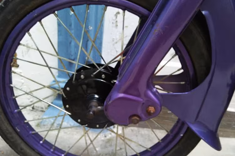 Là chiếc xe đời cũ, chiếc xe máy Honda Cub 50 trong bài viết được chủ nhân độ lại với ngoại thấ màu tím, cặp vành cũ cũng được sơn lại cùng tông màu với dàn áo. Moay ơ, cốp xe, hộp xích và cụm máy được sơn với tông màu đen bóng khá trẻ trung ấn tượng.