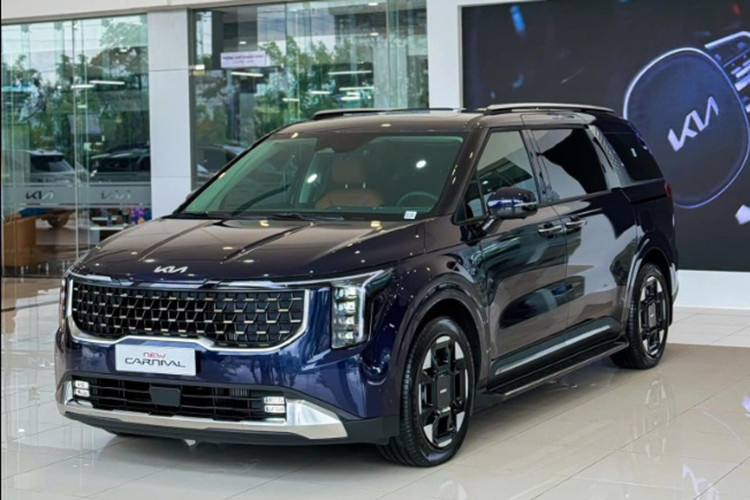 Phần đầu xe Kia Carnival gây ấn tượng với lưới tản nhiệt "mũi hổ" đặc trưng nhưng có thêm viền mạ crôm bao quanh. Xe có cụm đèn pha mới đặt dọc, kết hợp dải đèn LED ban ngày hình chữ T cách điệu. Bên cạnh đó là đèn sương mù nằm hai bên hốc gió trung tâm, cửa lùa chỉnh điện bên sườn và cản sau cải tiến.