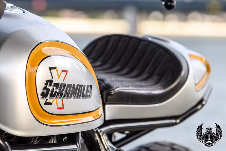 Với thiết kế bình xăng hình giọt nước, chiéc xe đã được tháo miếng ốp 2 bên bình xăng, cắt bỏ pát gắn ốp và làm láng bình xăng với logo Scrambler X.