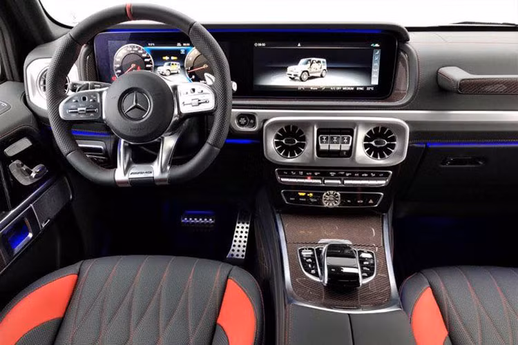 Điểm nhấn bên trong khoang lái của "ông vua địa hình" Mercedes-AMG G63 Edition 1 đời 2019 mới xuất hiện tại Việt Nam còn có sợi carbon màu đỏ ở bảng điều khiển trung tâm và các chi tiết như dây dai an toàn, viền ở trên đỉnh vô-lăng hay các đường chỉ may màu đỏ.