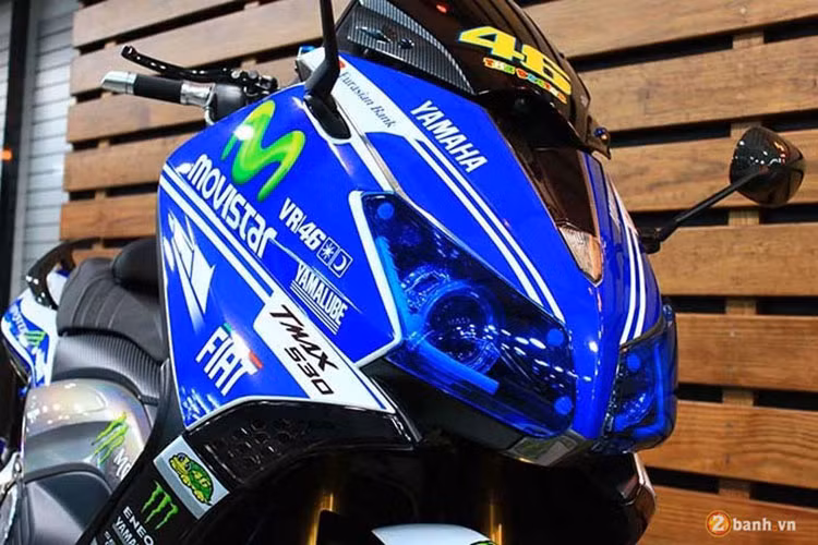 Dàn đầu đầy ấn tượng của chiếc xe tay ga cỡ lớn Yamaha TMax nhờ lớp áo tem đấu ở ngoài. Cặp đèn pha cũng được thay bằng lớp nhự màu xanh cho "sẹc tông" với toàn bộ thân xe.