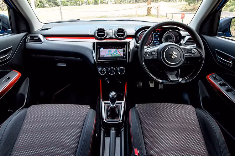 Các chi tiết màu đỏ còn rải rác ở thảm sàn, táp-lô, bảng đồng hồ, vô lăng và nẹp trong của cửa xe. Chính giữa bảng điều khiển là màn hình cảm ứng 7 inch, hiển thị các thông tin theo nhu cầu người dùng. Bên dưới là 3 núm điều chỉnh, điều khiển hệ thống điều hòa bên trong xe. Bên cạnh đó là nhiều nút điều chỉnh âm thanh, danh mục tùy chọn và bản đồ... 