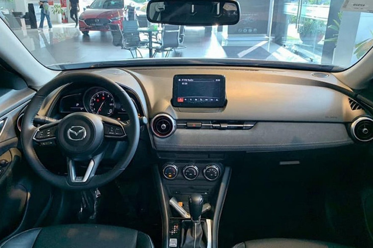 Bên trong xe, Mazda CX-3 1.5L AT sở hữu ghế bọc nỉ, màn hình cảm ứng trung tâm 7 inch và hệ thống âm thanh 6 loa. Ghế, điều hòa và gương chiếu hậu trung tâm của bản 1.5L AT mới đều là loại chỉnh cơ. Tuy nhiên, xe vẫn có phanh tay điện tử, tự động giữ phanh tạm thời, khởi động nút bấm và hệ thống ga tự động Cruise Control.