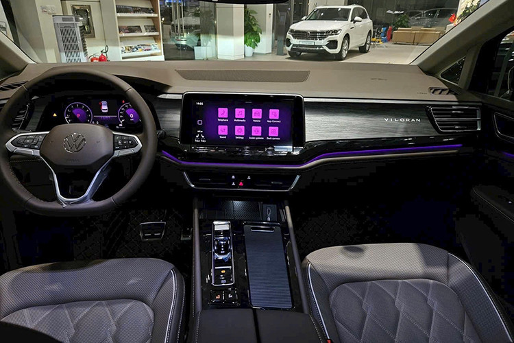 Hai hàng ghế này còn có bệ tì tay, khay để ly, khay để điện thoại, cổng sạc, hộc chứa đồ và cụm công tắc điều khiển riêng. Dù ở phiên bản nào, xe cũng có nội thất bọc da và ốp gỗ nên trông khá cao cấp. Bản thân trang bị tiện nghi của mẫu xe Volkswagen Viloran nhập khẩu nguyên chiếc từ Trung Quốc này cũng rất phong phú.