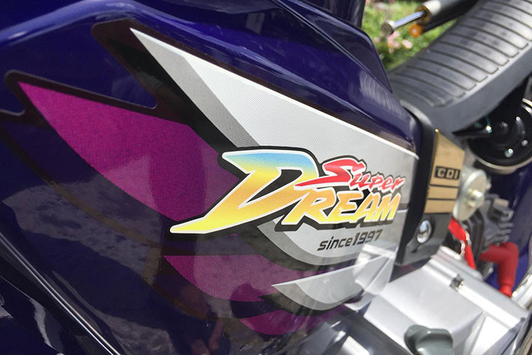 Trên chiếc xe Honda Dream chiến này, nó cũng đã được chủ nhân phối lại màu sắc bắt mắt hơn. Đáng chú ý là dải màu xanh ánh tím sáng bóng, đi kèm bộ tem đấu mang nhãn hiệu Honda Super Dream của Thái Lan.