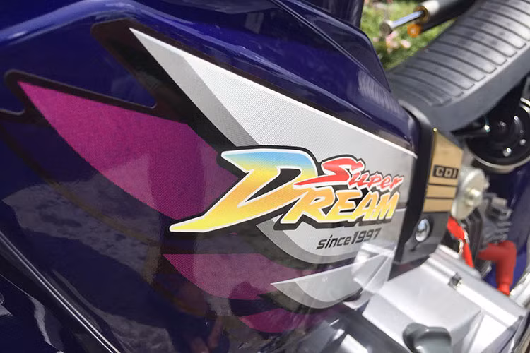 Trên chiếc xe Honda Dream chiến này, nó cũng đã được chủ nhân phối lại màu sắc bắt mắt hơn. Đáng chú ý là dải màu xanh ánh tím sáng bóng, đi kèm bộ tem đấu mang nhãn hiệu Honda Super Dream của Thái Lan.