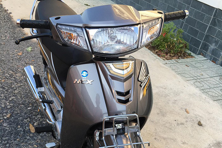 Xe sở hữu phần đầu với cụm đèn chiếu sáng và đèn hậu to bản dạng halogen, hai bên là đèn báo rẽ. Phía trước có giá gắn giỏ xe - chi tiết biến mất trên những chiếc xe máy phổ thông tại thị trường Việt Nam hiện nay.