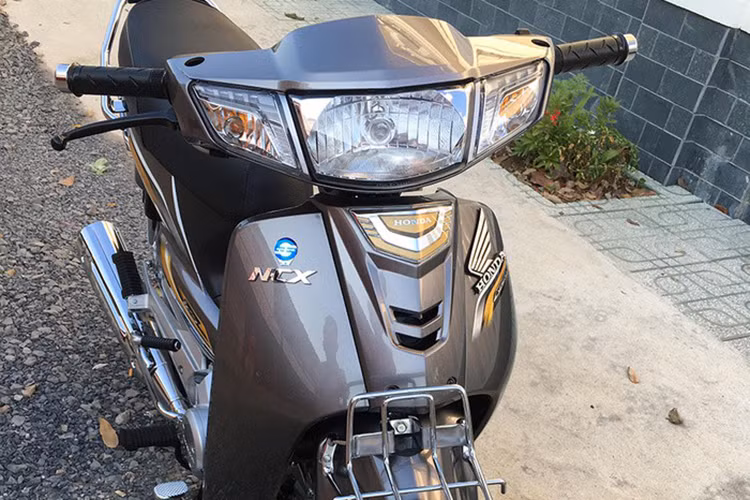 Xe sở hữu phần đầu với cụm đèn chiếu sáng và đèn hậu to bản dạng halogen, hai bên là đèn báo rẽ. Phía trước có giá gắn giỏ xe - chi tiết biến mất trên những chiếc xe máy phổ thông tại thị trường Việt Nam hiện nay.