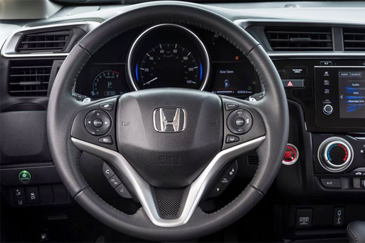 Vô lăng Honda Jazz 2018 với thiết kế kiểu thể thao 3 chấu. Phiên bản V và VX trang bị vô lăng urethan, trong khi phiên bản cao cấp nhất RS được bọc da thêu chỉ nổi thể thao và sang trọng. Trên vô lăng tất cả các phiên bản đều trang bị nút bấm điều khiển âm thanh, đàm thoại rảnh tay...