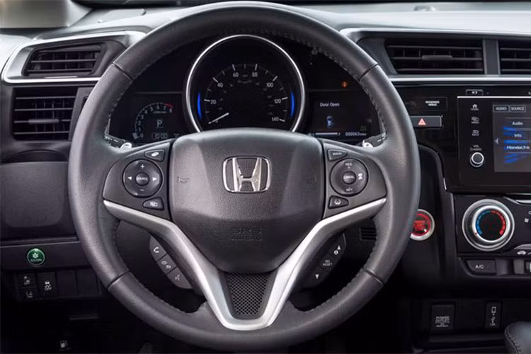 Vô lăng Honda Jazz 2018 với thiết kế kiểu thể thao 3 chấu. Phiên bản V và VX trang bị vô lăng urethan, trong khi phiên bản cao cấp nhất RS được bọc da thêu chỉ nổi thể thao và sang trọng. Trên vô lăng tất cả các phiên bản đều trang bị nút bấm điều khiển âm thanh, đàm thoại rảnh tay...