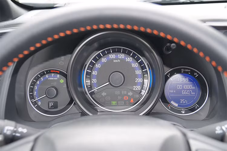 Phía sau vô lăng Honda Jazz 2018 là cụm đồng hồ lái analog đặc trưng những mẫu xe hạng B từ Honda. Trung tâm là đồng hồ tốc độ, bên trái nhỏ hơn là đồng hồ tua máy và bên phải là màn hình thông tin cung cấp các thông số vận hành. Điều đáng tiếc duy nhất, đây là màn hình tinh thể lỏng đơn sắc khá nhàm chán, nếu đây là màn hình LCD tương tự thị trường Mỹ thì nội thất Jazz sẽ thêm phần hiện đại hơn.