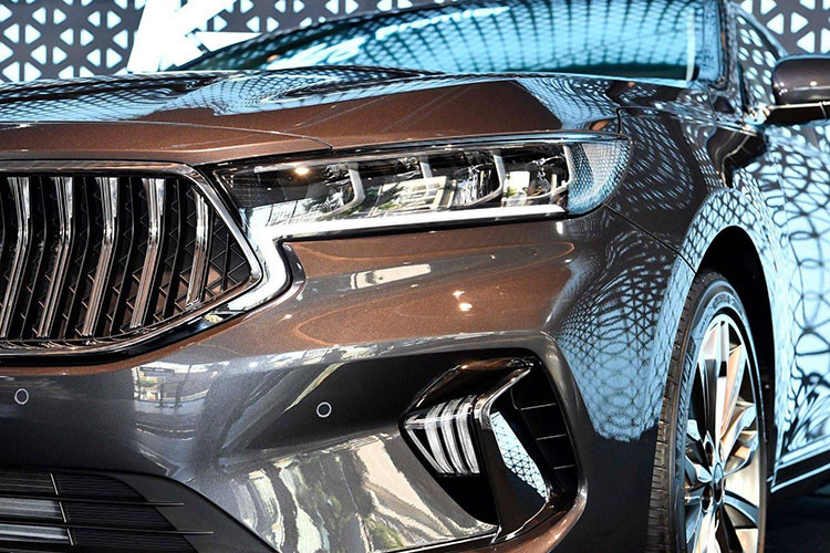 Trên Kia K7 2019 mới, nó được các kỹ sư thiết kế Hàn Quốc áp dụng hơi hướng mới, đơn giản và tinh tế hơn nhiều so với "người tiền nhiệm". Ở phần đầu xe, mặt ca-lăng được tái thiết kế với dấu ấn hình mũi hổ đặc trưng sắc nét hơn. Cụm đèn chiếu sáng chính không còn rườm rà mà gọn gàng hơn và thêm đèn Full-Led hiện đại.