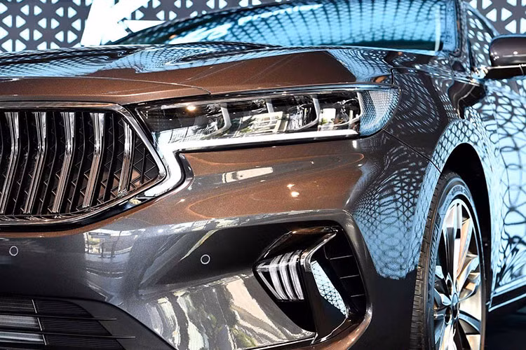 Trên Kia K7 2019 mới, nó được các kỹ sư thiết kế Hàn Quốc áp dụng hơi hướng mới, đơn giản và tinh tế hơn nhiều so với "người tiền nhiệm". Ở phần đầu xe, mặt ca-lăng được tái thiết kế với dấu ấn hình mũi hổ đặc trưng sắc nét hơn. Cụm đèn chiếu sáng chính không còn rườm rà mà gọn gàng hơn và thêm đèn Full-Led hiện đại.