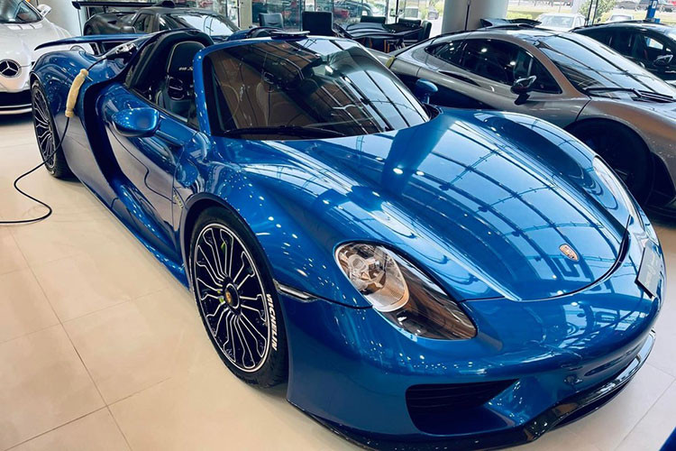 Porsche 918 Spyder màu xanh, đỗ cạnh còn có McLaren P1 và còn 1 xe Porsche 918 Spyder khác đỗ góc bên trái, có 918 xe Porsche 918 Spyder được sản xuất và 375 xe McLaren P1 ra đời. Hiện tại, còn có 5 xe McLaren P1 Spider hứa hẹn sẽ sớm được 1 hãng độ bàn giao đến cho khách hàng.