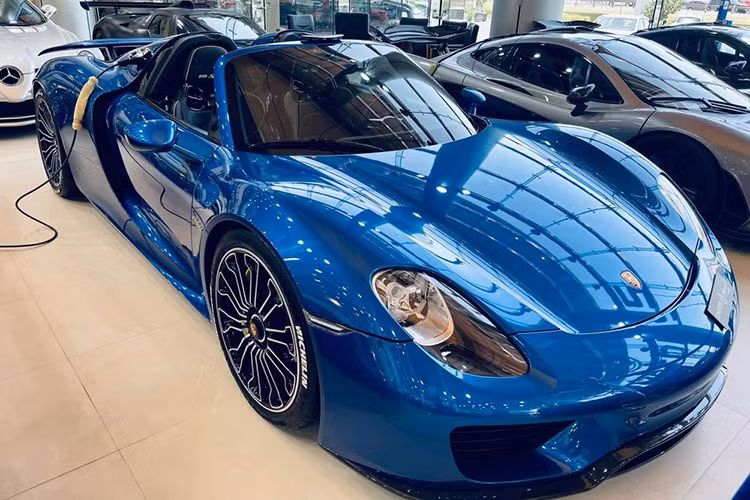 Porsche 918 Spyder màu xanh, đỗ cạnh còn có McLaren P1 và còn 1 xe Porsche 918 Spyder khác đỗ góc bên trái, có 918 xe Porsche 918 Spyder được sản xuất và 375 xe McLaren P1 ra đời. Hiện tại, còn có 5 xe McLaren P1 Spider hứa hẹn sẽ sớm được 1 hãng độ bàn giao đến cho khách hàng.