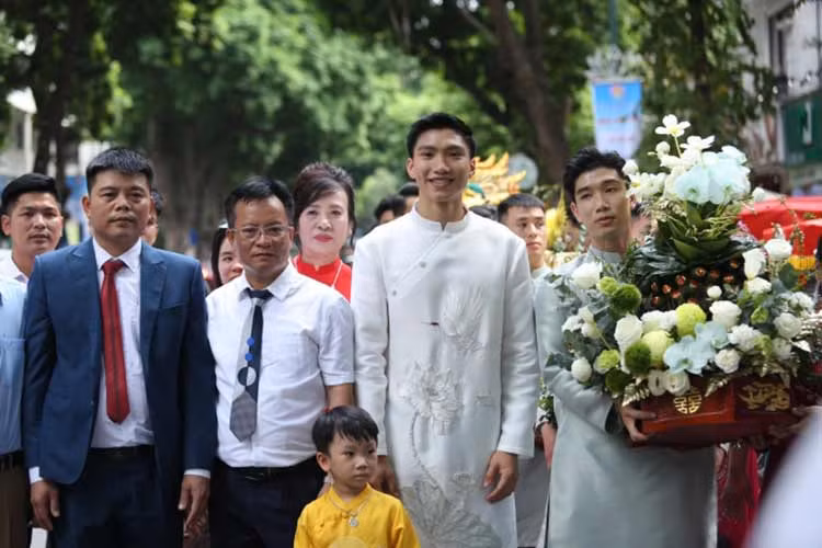 Chàng cầu thủ sinh năm 1999 diện chiếc áo dài trắng - thiết kế có tên Bạch Hạc Liên Hương, họa tiết hoa sen chim hạc vừa hiện đại vừa tôn lên vẻ truyền thống của đám cưới Việt Nam.