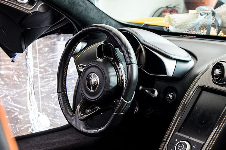 Bên trong khoang cabin, McLaren 650S Spider cũng giống nhiều siêu xe khác khi mọi khu vực được bố trí đơn giản, xe không tập trung sự hưởng thụ của người dùng. Vô-lăng xe dạng D-Cut bọc da, ốp carbon, màn hình trung tâm đặt dọc cùng hàng loạt nút bấm ở đây kể cả nút khởi động.