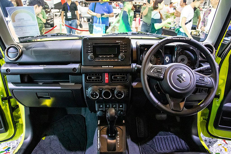 Bên trong Suzuki Jimny 2019, khách hàng sẽ tìm thấy những trang bị như vô lăng 3 chấu bọc da, chỉnh điện 2 hướng, tích hợp phím chức năng, cửa sổ chỉnh điện bên ghế lái, khóa điều khiển từ xa, hệ thống điều hòa tự động với lọc không khí, màn hình đa thông tin trong bảng đồng hồ, tay nắm cửa mạ crôm, ghế bọc nỉ màu đen, ghế lái chỉnh tay 6 hướng...