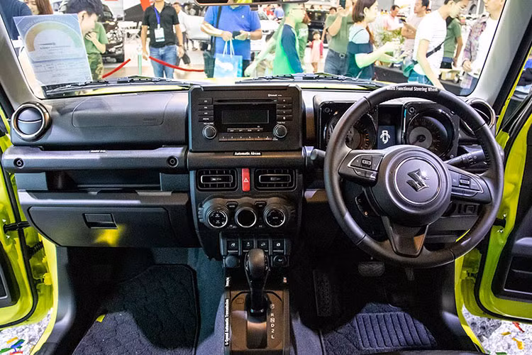 Bên trong Suzuki Jimny 2019, khách hàng sẽ tìm thấy những trang bị như vô lăng 3 chấu bọc da, chỉnh điện 2 hướng, tích hợp phím chức năng, cửa sổ chỉnh điện bên ghế lái, khóa điều khiển từ xa, hệ thống điều hòa tự động với lọc không khí, màn hình đa thông tin trong bảng đồng hồ, tay nắm cửa mạ crôm, ghế bọc nỉ màu đen, ghế lái chỉnh tay 6 hướng...