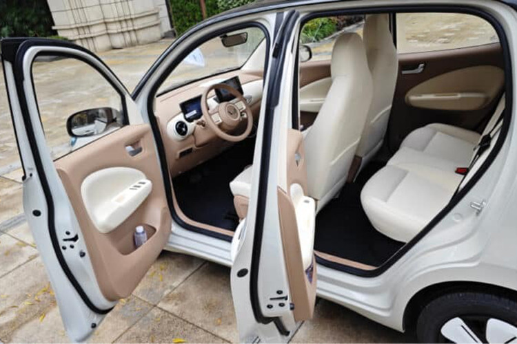 Khoang lái của Wuling Hongguang Mini EV 5 cửa được nâng cấp với màn hình giải trí 8 inch, bảng đồng hồ kỹ thuật số LCD và bốn ghế ngồi tích hợp tựa đầu. Khung xe dạng vòng tròn gia cố với 67% thép cường lực, đi kèm hai túi khí.