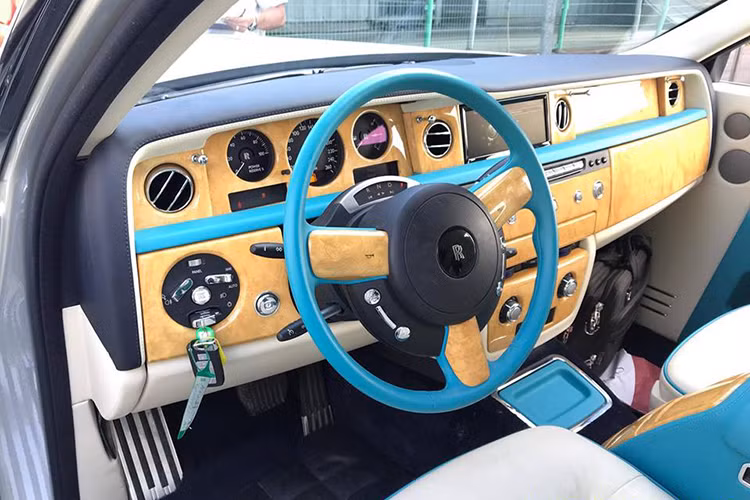 Cụ thể, nội thất chiếc xe siêu sang Rolls-Royce Phantom Series II này có ghế ngồi được bọc da màu trắng muốt cùng nhiều chi tiết như hộc đựng đồ, bệ tỳ tay hay đáng chú ý nhất chính là vô-lăng được hoàn thành với màu xanh ngọc giống phong cách của giới nhà giàu Dubai.
