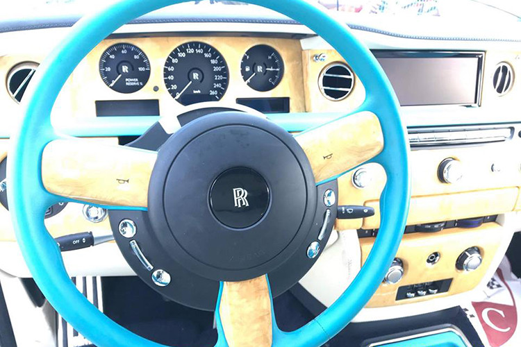 Chưa hết, toàn bộ bảng táp-lô và bảng điều khiển trung tâm của chiếc xe siêu sang này còn được ốp gỗ quý màu vàng nhạt với đường kẻ màu xanh ngọc đẹp mắt. Đây có thể xem là chiếc Rolls-Royce Phantom có nội thất "sexy" nhất tại Việt Nam tính đến thời điểm hiện tại.