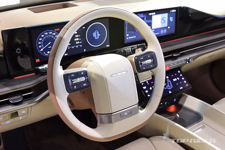 Trước mặt người lái là vô lăng vát đáy thể thao, lấy cảm hứng thiết kế từ Hyundai Grandeur thế hệ đầu tiên. Tiếp đó là bảng đồng hồ kỹ thuật số 12,3 inch, nối liền với màn hình cảm ứng trung tâm 10,25 inch trên mặt táp-lô và cửa gió điều hòa hình chữ nhật kéo dài với viền kim loại.