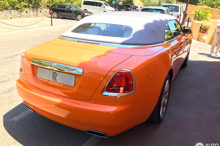 Điểm nhấn trên chiếc xe màu cam là nắp capô và mui vải được hoàn thành màu bạc cùng các chi tiết khác như lưới tản nhiệt, viền đèn hậu, tay nắm cửa, 2 hốc gió trước và la-zăng mạ crôm sáng loáng. Hiện chưa rõ bên trong khoang lái chiếc Rolls-Royce Dawn này có "nội y" màu gì nhưng chỉ riêng việc trang bị bộ áo cam cũng mang đến sự nổi bật.