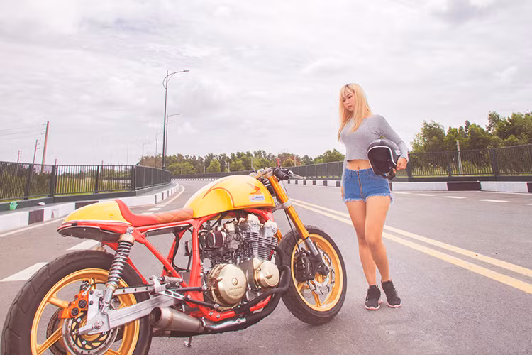 Chiếc xe môtô Honda CB750F đời 1981 lột xác theo phong cách cafe racer với tông màu cam vàng của đội đua Repsol Racing, cùng nhiều trang bị hiện đại có dịp "ngược nắng" cùng cô nàng teen girl Sài Thành cá tính.