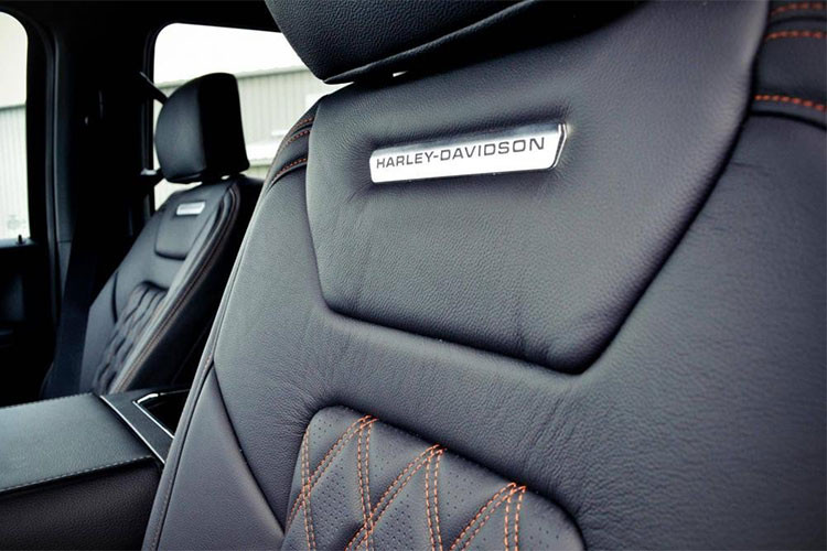 Thậm chí nếu bạn là người yếu thích xe môtô Harley, có thể thấy rõ ở mặt đồng hồ xe cũng có logo hãng và sắc cam đặc trưng này. Trên lưng ghế và thảm sàn cũng được trang trí dòng chữ Harley-Davidson.