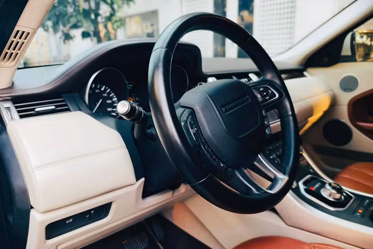 Bên trong khoang cabin Range Rover Evoque sang chảnh sử dụng chất liệu da hai tông màu, chủ đạo là màu vàng da bò. Ghế ngồi còn khá căng, ít vết nhăn nhưng vô lăng có dấu hiệu mòn bóng do sử dụng lâu năm. Chủ xe tương lai có thể bọc lại da vô lăng với chi phí khoảng vài triệu đồng. 