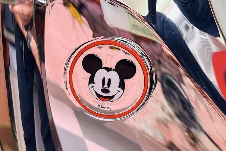 Bên cạnh đó, ở phần ốp nằm ngay cạnh cùm khoá, Honda cũng có một mảng kim loại đánh dấu phiên bản giới hạn x/100. Ở phiên bản thông thường, khu vực ốp này sẽ có phần nắp được làm bằng crom bóng, nhưng trên phiên bản Disney thì lại được làm bằng nhựa nhám.