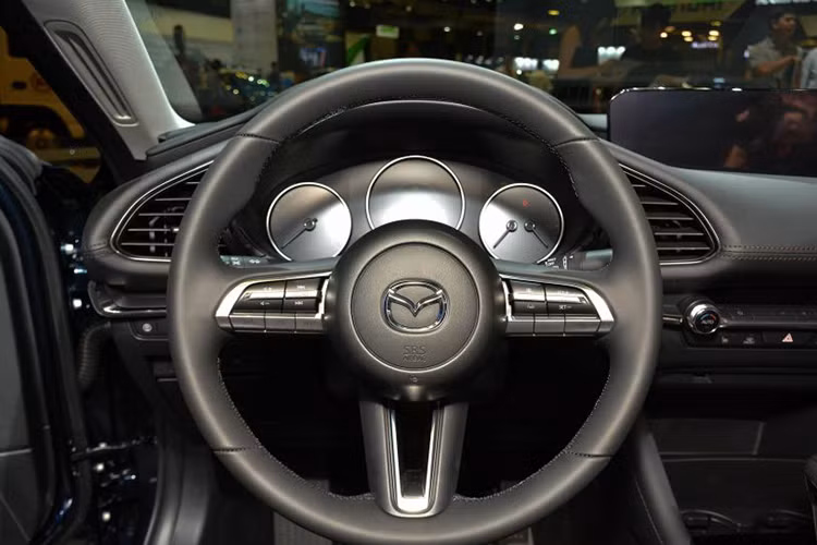 Với người lái, Mazda3 2019 chào đón bằng vô lăng có thiết kế mới và bảng đồng hồ đơn giản hóa với 3 đồng hồ hình tròn. Ngay bên dưới màn hình giải trí là các nút chỉnh điều hòa, nằm ngang hàng với cửa gió hình chữ nhật. Cụm điều khiển trung tâm xuất hiện cần số và các nút chỉnh hệ thống thông tin giải trí.