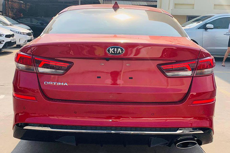 Ở phía sau, cụm đèn hậu của bản nâng cấp Kia Optima 2019 được thiết kế lại với đồ họa chiếu sáng mới sắc nét và tinh tế hơn, bổ sung hai tấm phản quang. Bộ khuếch tán khí động học được sơn đen bóng, có thêm thanh mạ chrome. Hai ống xả hình oval cỡ lớn được đặt đối xứng nhau.